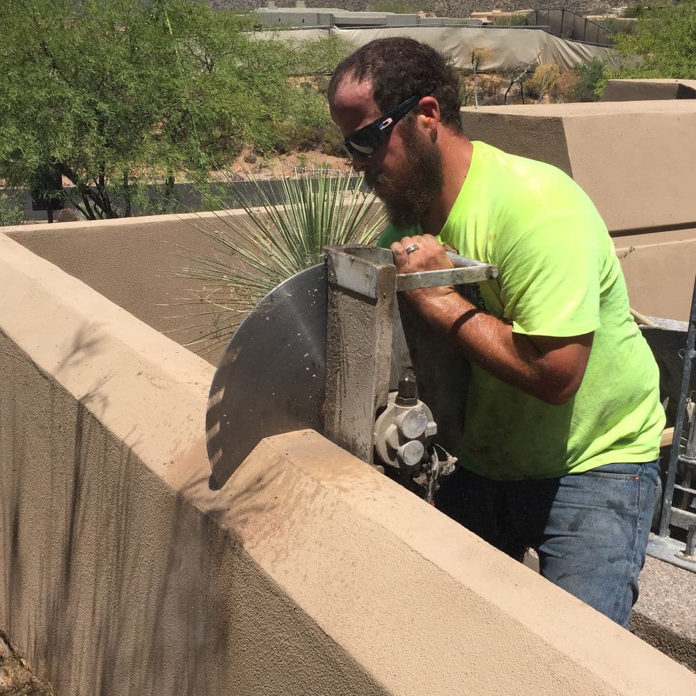 man hand sawing a concrete wall